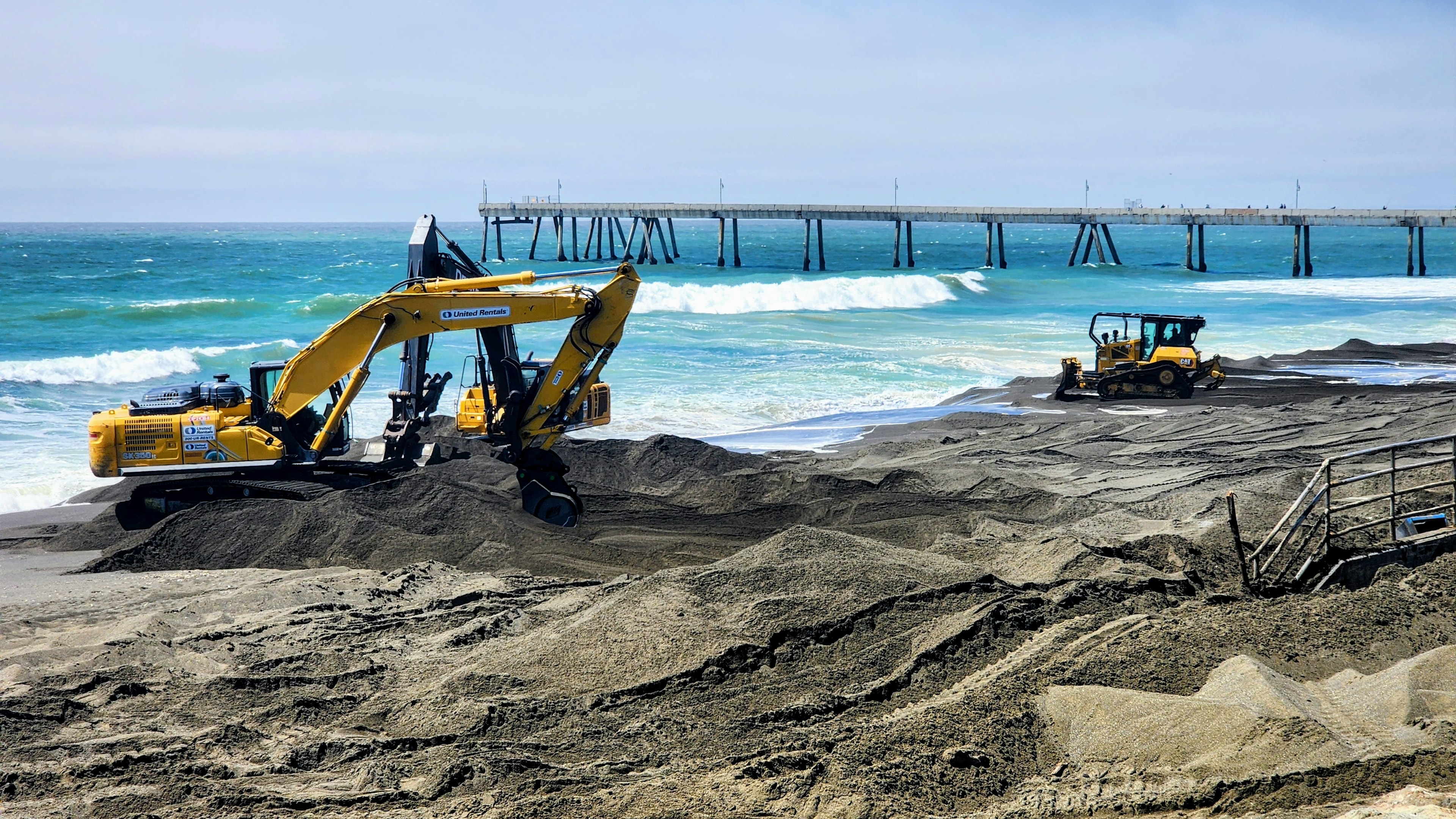 Heavy equipment moving sand on Pacifica Beach as part of coastal sand retention work